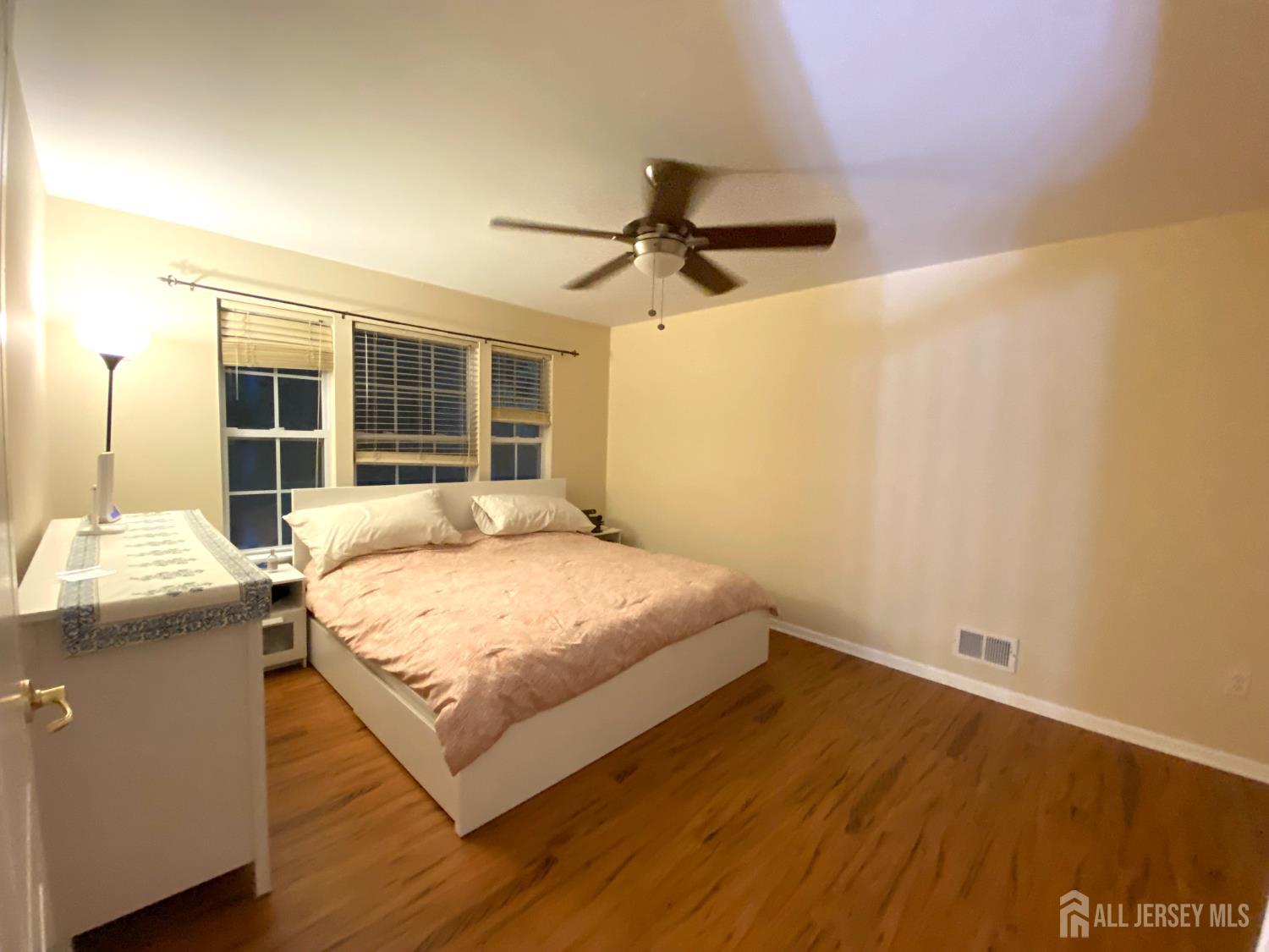 228 Hawthorne Road North Brunswick, NJ 08902 - Photo 9 of 23 a bedroom with a bed and a table with wooden floor