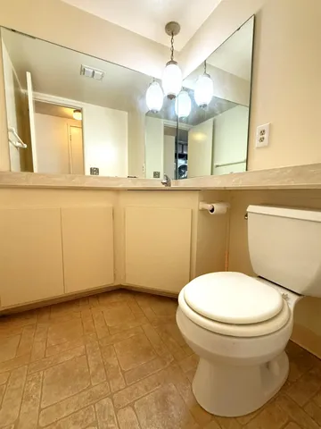 a bathroom with a granite countertop toilet sink and shower
