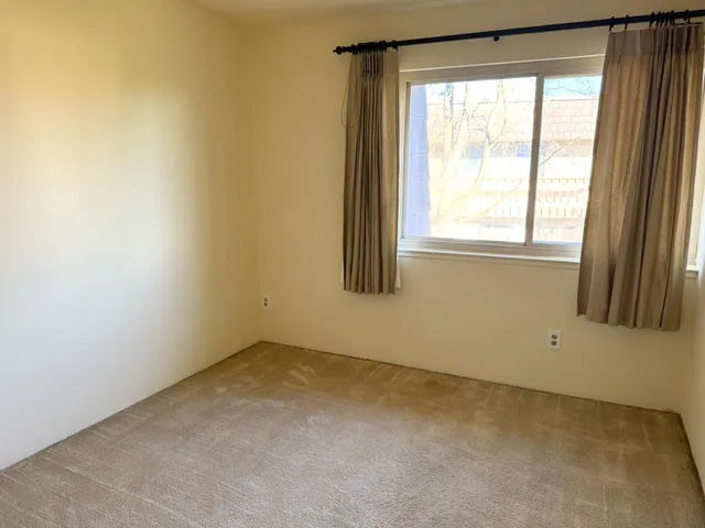 an empty room with a ceiling fan and a bathroom
