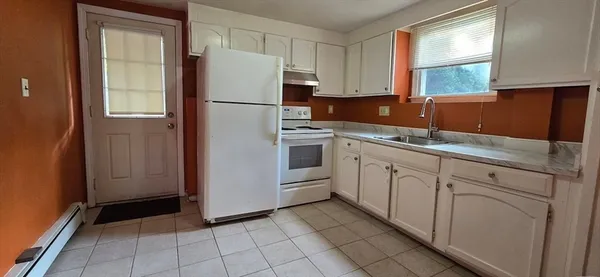 a kitchen with white cabinets and white appliances