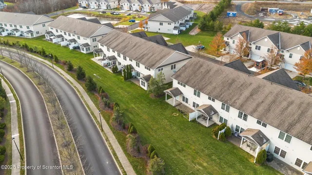 an empty room with wooden floor ceiling fan and windows
