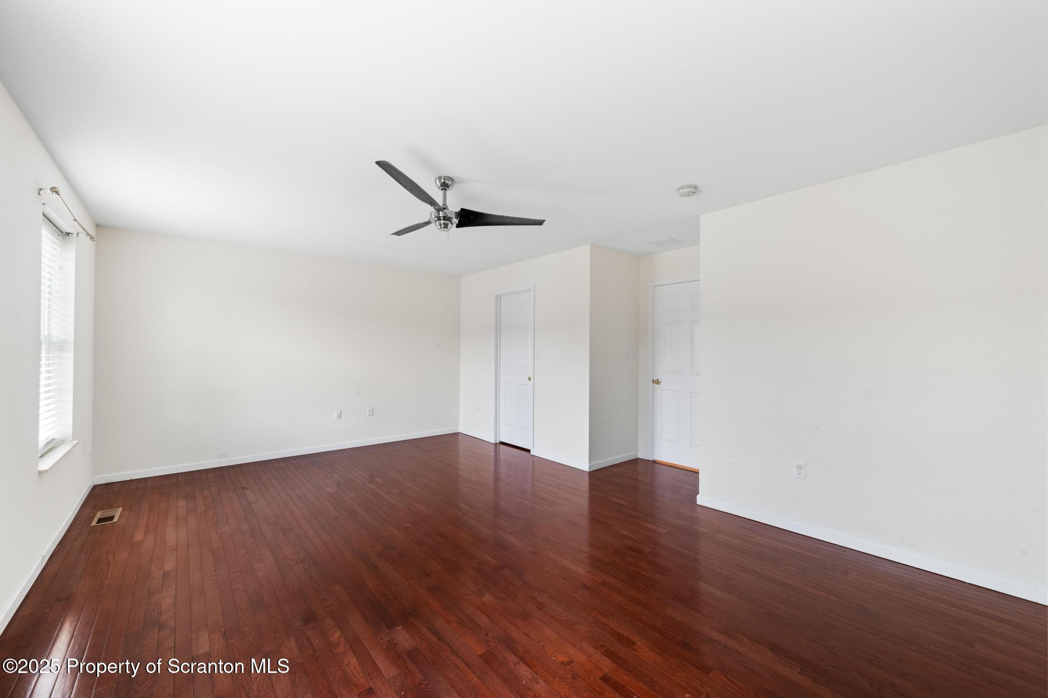 192 Shadow Wood Circle Archbald, PA 18403 - Photo 22 of 55 a view of an empty room with wooden floor and a ceiling fan