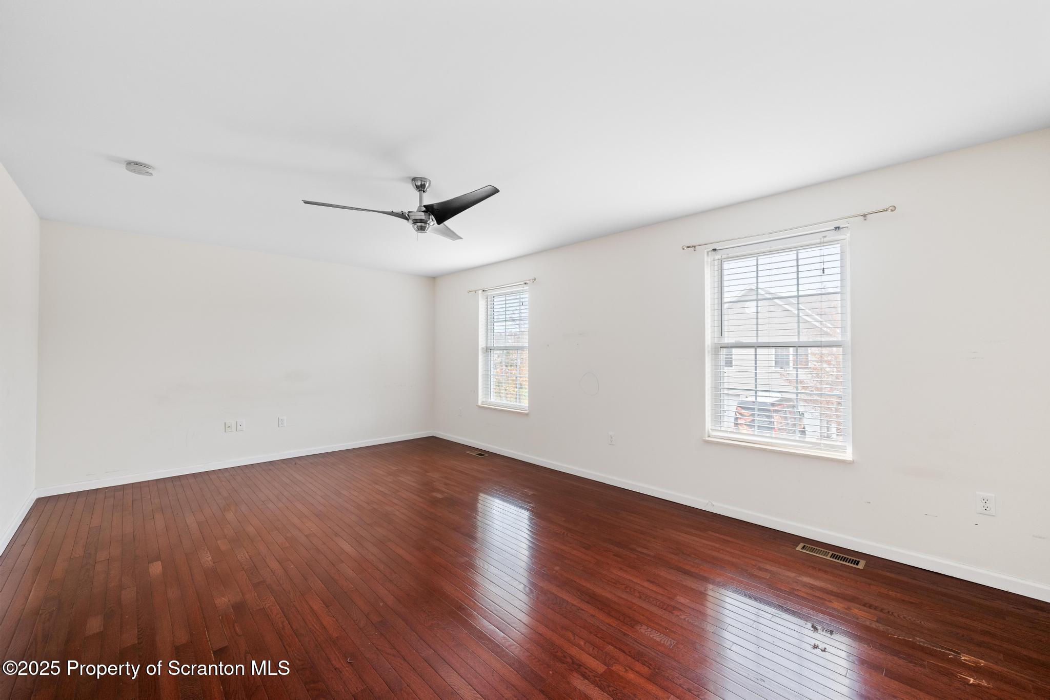 192 Shadow Wood Circle Archbald, PA 18403 - Photo 23 of 55 an empty room with wooden floor ceiling fan and windows