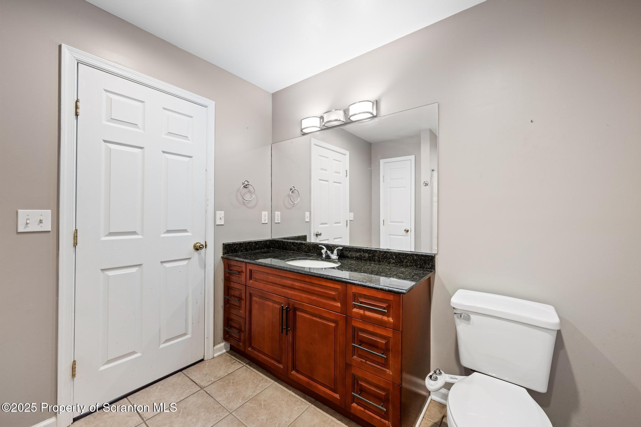192 Shadow Wood Circle Archbald, PA 18403 - Photo 30 of 55 a bathroom with a granite countertop toilet sink and mirror