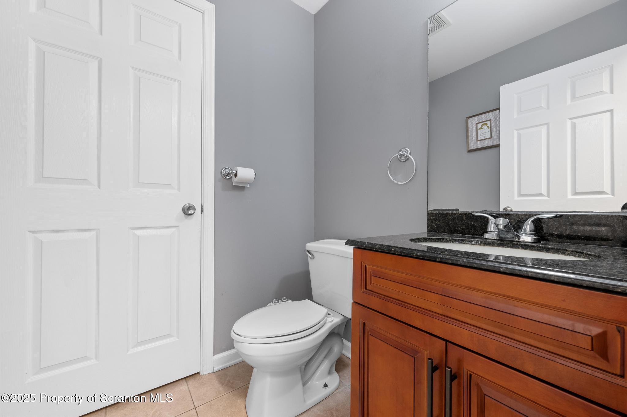 192 Shadow Wood Circle Archbald, PA 18403 - Photo 31 of 55 a bathroom with a granite countertop toilet a sink and a mirror