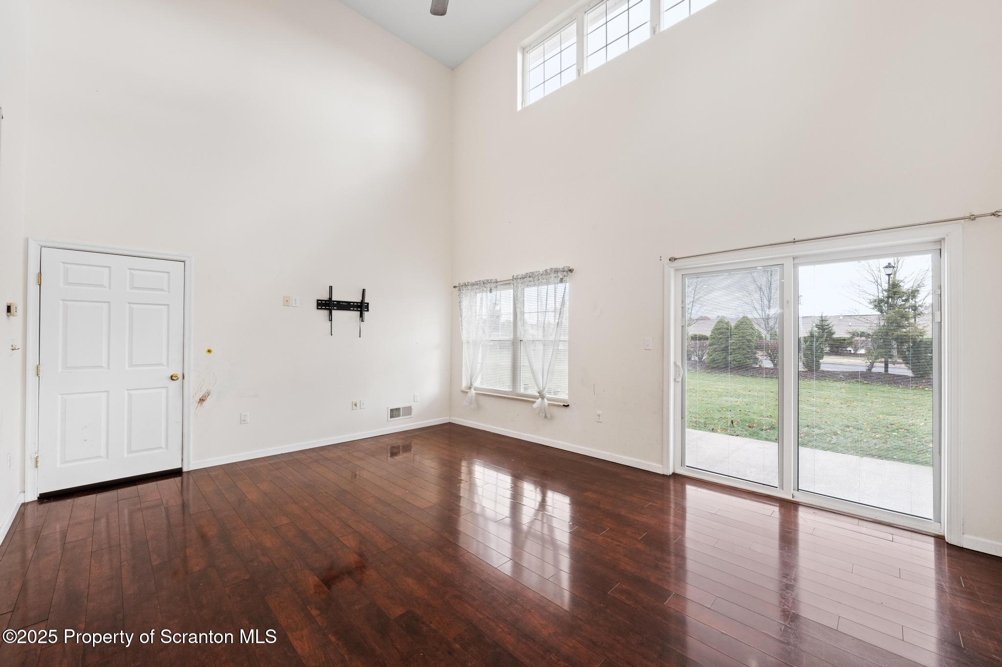 192 Shadow Wood Circle Archbald, PA 18403 - Photo 9 of 55 an empty room with wooden floor and windows