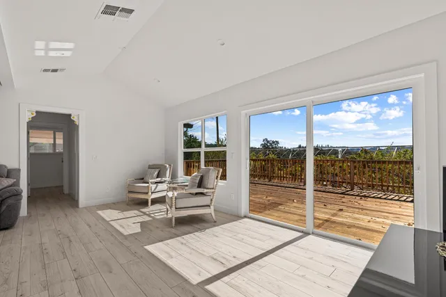 a living room with furniture and large windows