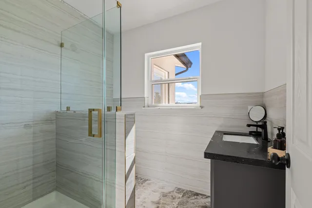 a bathroom with a granite countertop sink a toilet and a shower