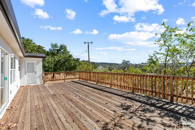 a view of a livingroom with wooden floor and a refrigerator