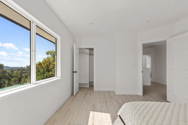 a view of hallway with a large window and wooden floor