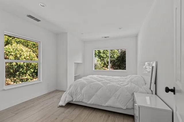 a bathroom with a sink mirror toilet and next to a window