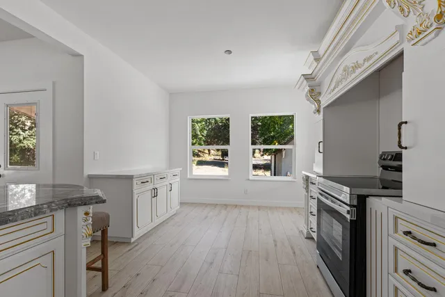 a kitchen with granite countertop a stove top oven sink and cabinets