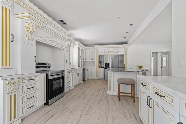 a kitchen with white cabinets and appliances