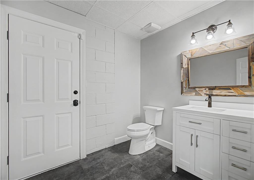1445 Hillside Drive Southwest Grayson, GA 30017 - Photo 70 of 85 a bathroom with a toilet sink double vanity and mirror