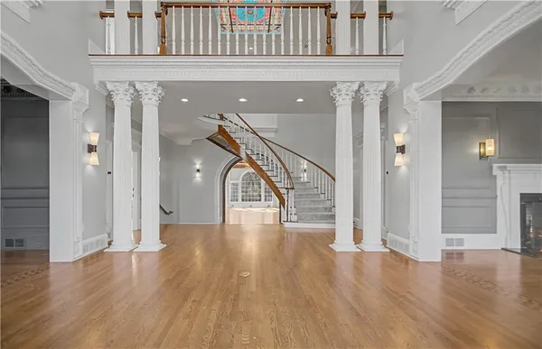 a view of a hallway with wooden floor a fireplace and a window