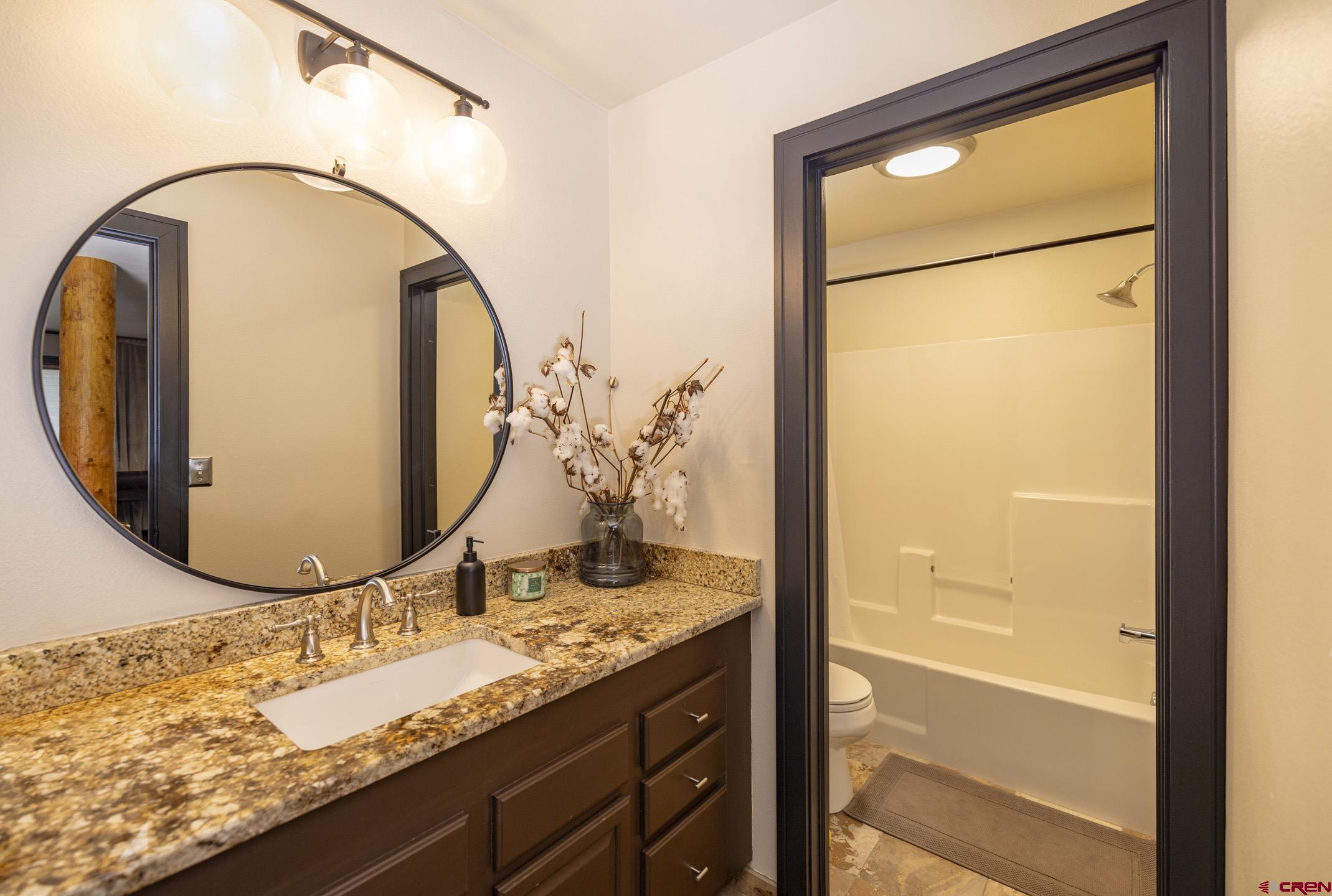 154 Falcon Ridge Road Durango, CO 81301 - Photo 33 of 42 a bathroom with a granite countertop sink and a mirror