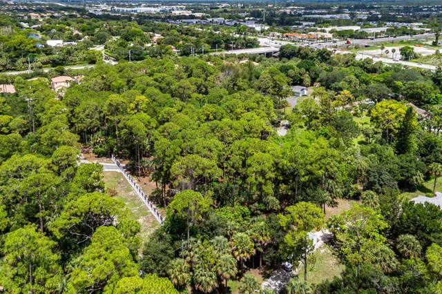 an aerial view of residential houses with outdoor space and trees