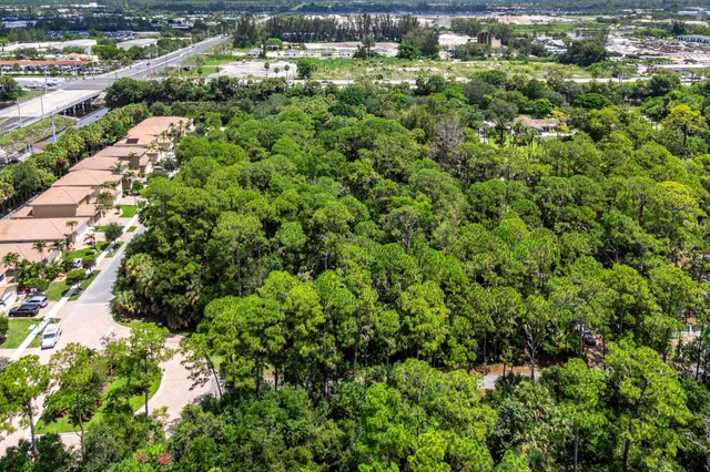 an aerial view of residential houses with outdoor space and trees all around