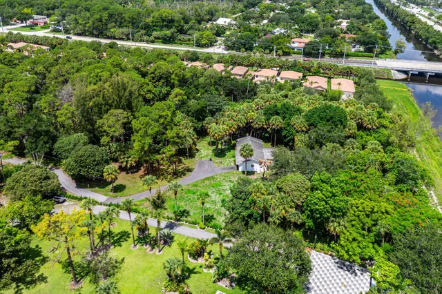 an aerial view of residential houses with outdoor space and trees