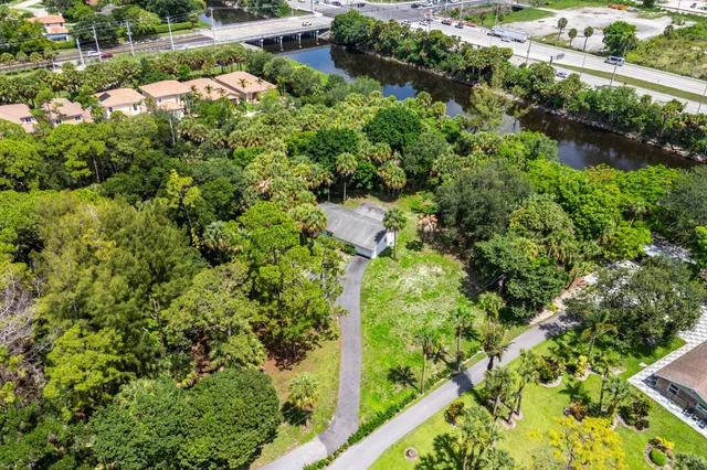 an aerial view of residential house with outdoor space and trees all around