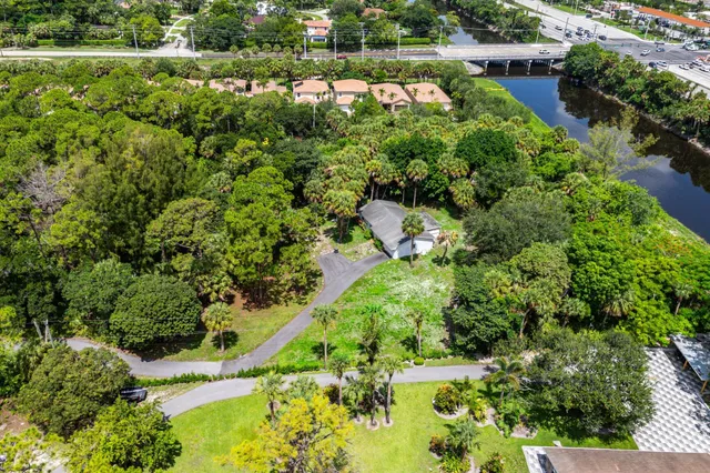an aerial view of residential house with outdoor space and trees all around