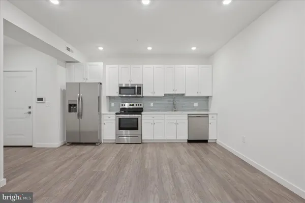 a kitchen with stainless steel appliances a refrigerator and a stove top oven
