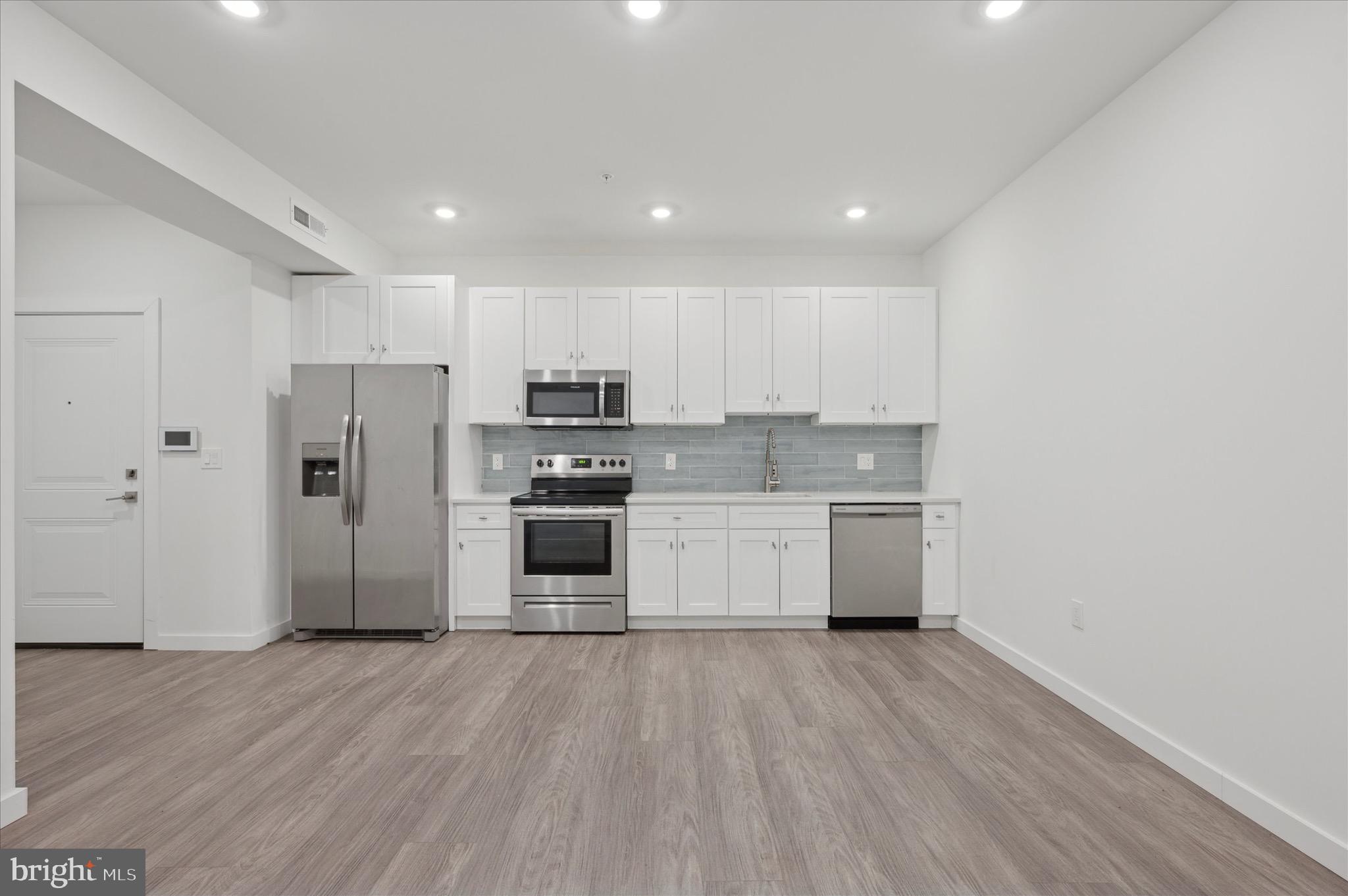 1617-19 Ridge Avenue, Unit C Philadelphia, PA 19130 - Photo 5 of 26 a kitchen with stainless steel appliances a refrigerator sink and white cabinets