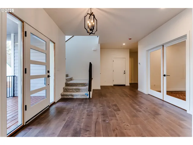 a kitchen with stainless steel appliances a dining table chairs refrigerator and microwave