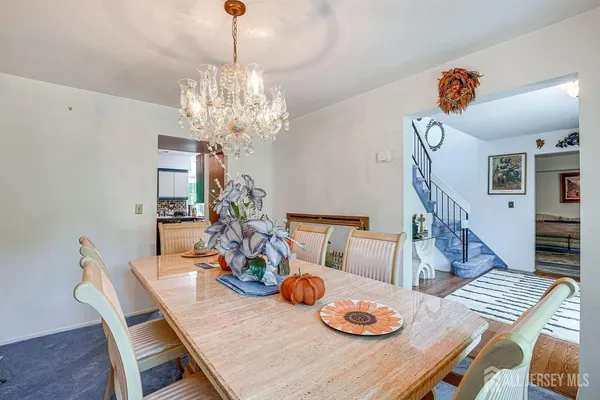 a view of a dining room with furniture a chandelier and wooden floor