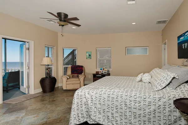 a bedroom with a bed couches and flat screen tv