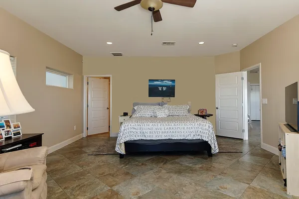 a bedroom with a bed a lamp and a flat screen tv