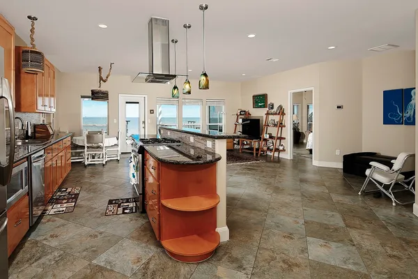 a kitchen with stainless steel appliances granite countertop a stove a sink a dining table chairs and view kitchen