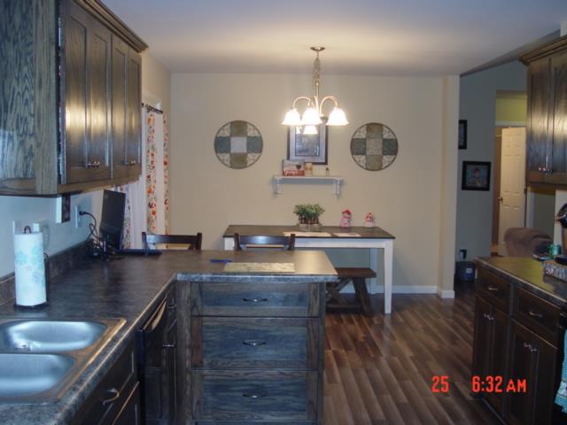 1360 McCool Road Lewisburg, TN 37091 - Photo 12 of 27 a kitchen with cabinets a sink dishwasher a dining table and chairs with wooden floor
