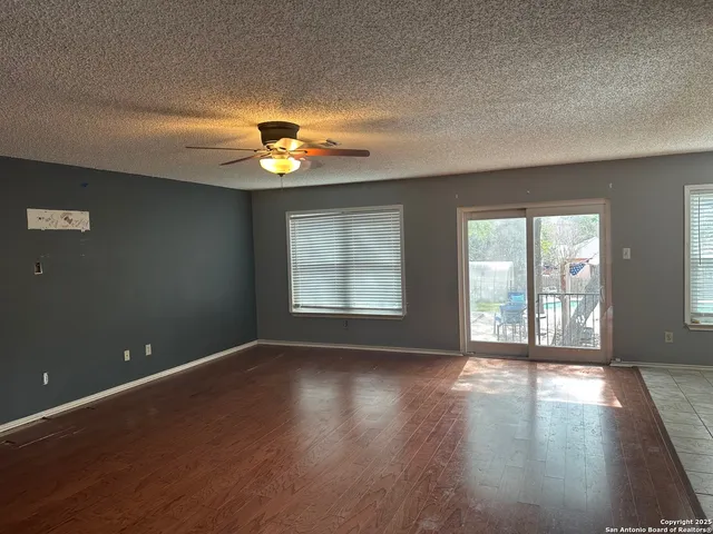 an empty room with wooden floor and a window