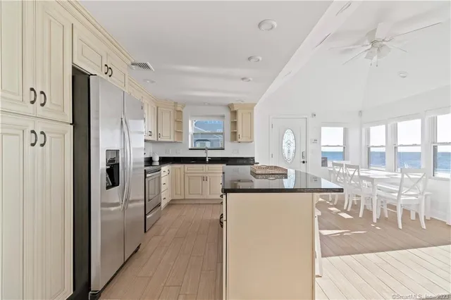a living room with stainless steel appliances granite countertop furniture a fireplace and a window