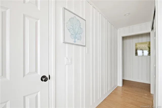 a view of a hallway with wooden floor and staircase