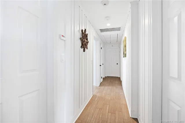 a view of a room with wooden floor and a hallway
