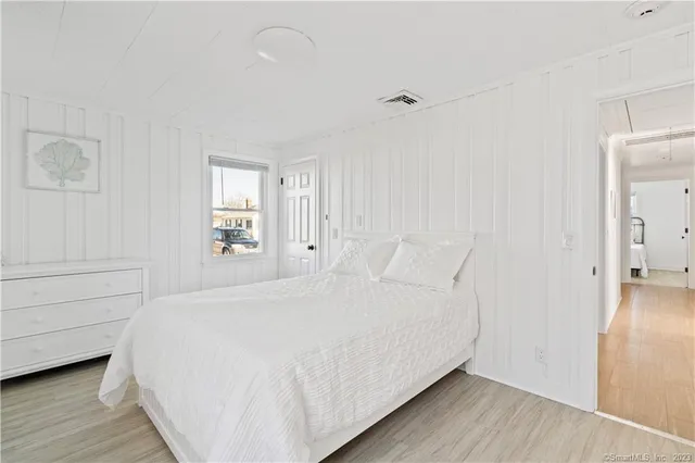 a bedroom with a bed and a flat tv screen on dresser