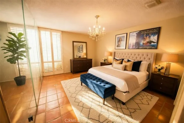 a bedroom with a large bed and a chandelier