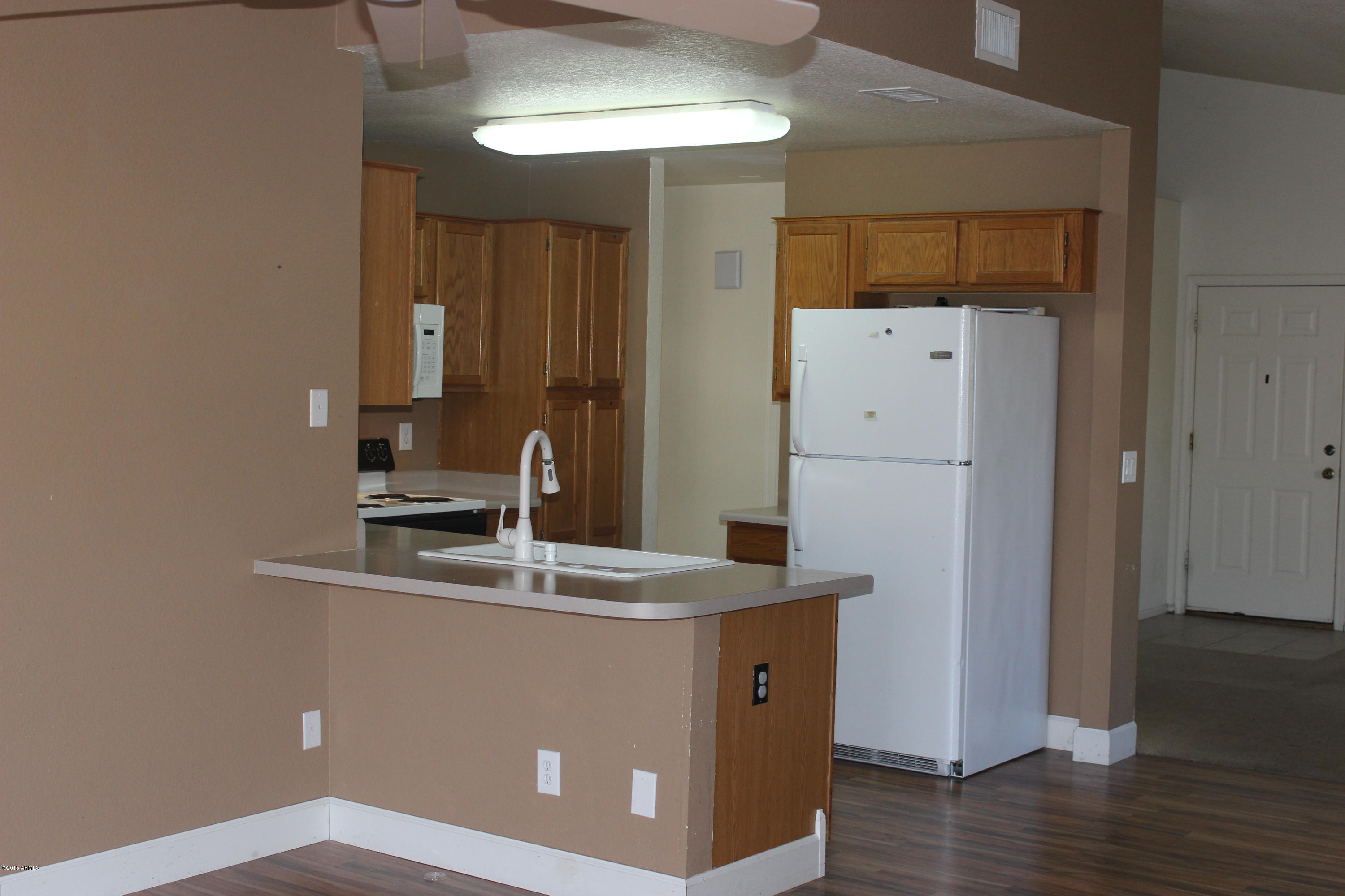 5028 Casper Road Mesa, AZ 85205 - Photo 11 of 33 a kitchen with kitchen island a sink a stove and a refrigerator