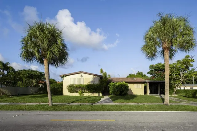 a front view of a house with garden and yard