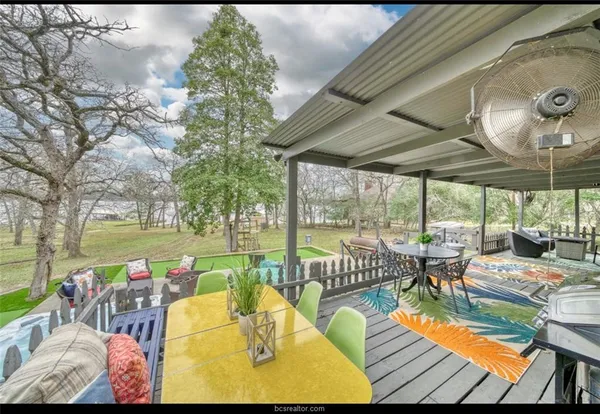 a view of a patio with lawn chairs and wooden floor