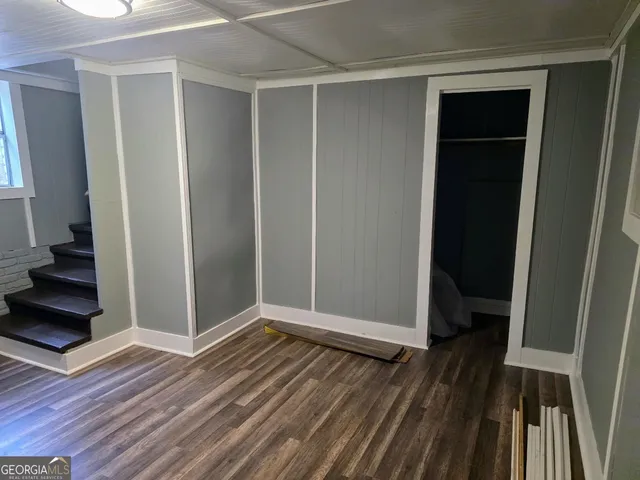 an empty room with wooden floor and closet