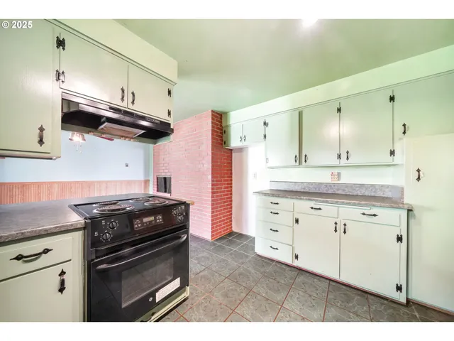 a kitchen with cabinets stainless steel appliances and wooden floor