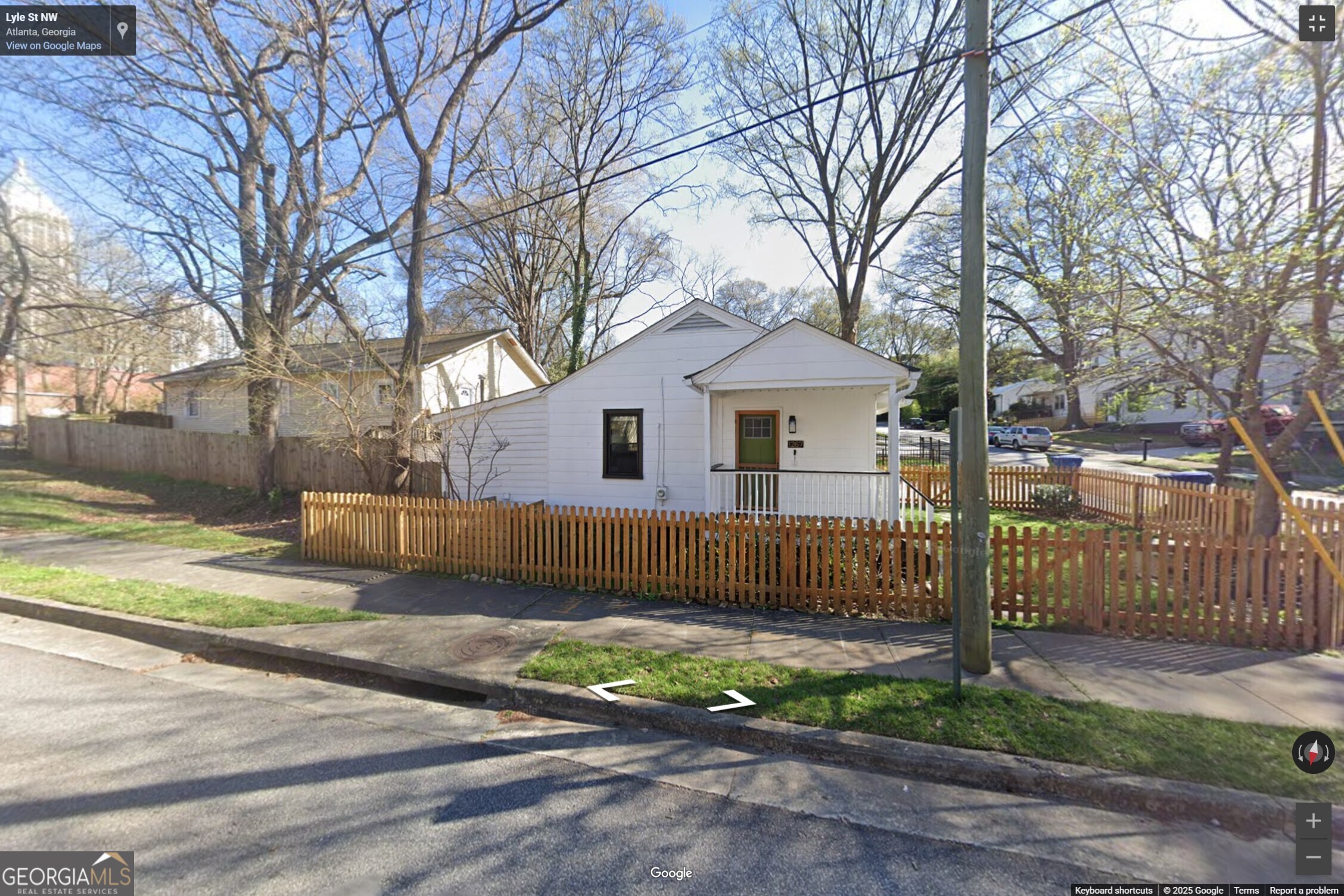 1267 Lyle Place Northwest, Unit 1267 Atlanta, GA 30318 - Photo 1 of 8 a view of a white house with a small yard and large tree
