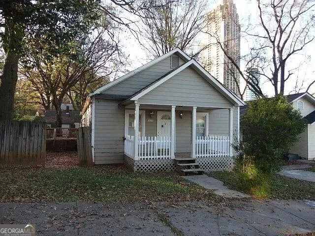 a view of a house with a yard and large tree