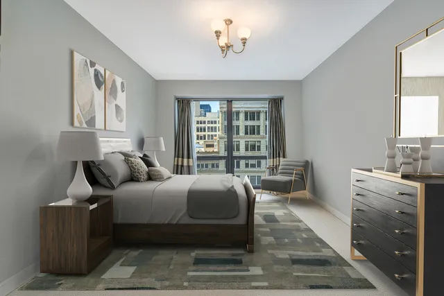 a spacious bedroom with a bed a couch and a large window