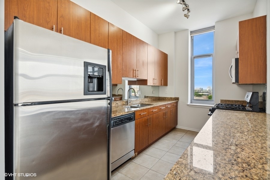 1201 West Adams Street, Unit 701 Chicago, IL 60607 - Photo 12 of 29 a large kitchen with stainless steel appliances granite countertop a refrigerator and a sink