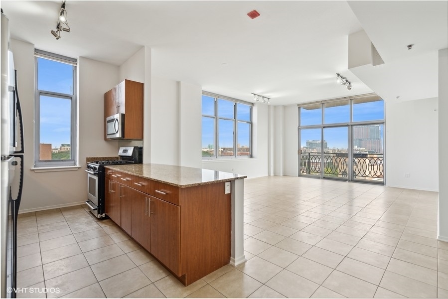 1201 West Adams Street, Unit 701 Chicago, IL 60607 - Photo 3 of 29 a large kitchen with stainless steel appliances granite countertop a sink and cabinets
