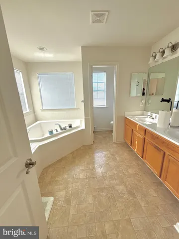 a view of kitchen with stainless steel appliances cabinets and window